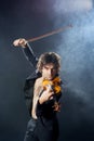 Violinist a player with a violin instrument in his hands. Artist of classical music or alternative music direction. Concept of Royalty Free Stock Photo