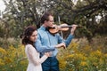 Violinist and woman in white dress , young man plays on the violin the background nature Royalty Free Stock Photo