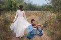 Violinist and woman in white dress , young man plays on the violin the background nature Royalty Free Stock Photo