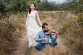 Violinist and woman in white dress , young man plays on the violin the background nature Royalty Free Stock Photo