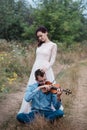 Violinist and woman in white dress , young man plays on the violin the background nature Royalty Free Stock Photo