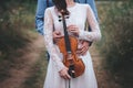 Violinist and woman in white dress , young man plays on the violin the background nature