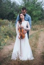 Violinist and woman in white dress , young man plays on the violin the background nature