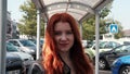 Vire, France - May 20, 2023: Portrait of a young woman with long red hair on a sunny day