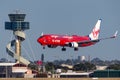 Virgin Blue Airlines Boeing 737 airliner landing at Sydney Airport with the air traffic control tower in the background Royalty Free Stock Photo