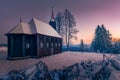 Virgin Mary Church in Grun, Beskid Mountains. Beautiful small wooden church. Winter fairytale picture. Sky glows on the