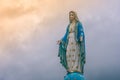 Virgin Mary statue at Catholic church with sunlight in cloudy day background. Royalty Free Stock Photo