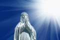 Virgin Mary statue. Vintage sculpture of sad woman in sunlight Royalty Free Stock Photo