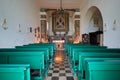 Virgin of the Snow ancient church interior with green pews on mountain top in Prato Nevoso, Italy