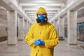 Virologist in a protective yellow suit and a respirator in the hospital.