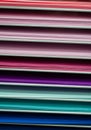 Virtical stacks of colored paper in various shades of pink, red and purple, turquoise and blue
