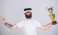 Virtual achievement concept. Hipster on happy face won virtual championship. Guy with VR glasses won championship, hold