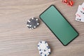 Virtual casino game with smartphone on table and objects around Royalty Free Stock Photo