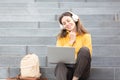 Virtual date. Smiling caucasian woman in wireless headphones sits on the steps of the stairs and chatting on a laptop Royalty Free Stock Photo