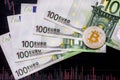 Virtual money golden bitcoin on hundred euro bills and paper forex chart background. Exchange bitcoin cash for a euro