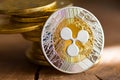 Virtual money Ripple cryptocurrency - pile of coins and gold XRP coin on the wooden background