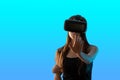 Virtual reality and the digital world. Girl gamer in VR helmet isolated on a blue background Royalty Free Stock Photo