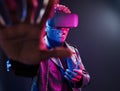 Virtual reality experience. Futuristic neon lighting. Young african american man in the studio