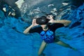 Virtual reality simulator. An unusual girl swims underwater in the pool in black virtual reality glasses on her head. Shooting und