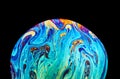 Virtual reality space with abstract multicolor psychedelic planet. Closeup Soap bubble like an alien planet on black background Royalty Free Stock Photo