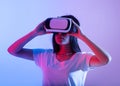 Portrait of serious teen asian woman in vr glasses playing in online game with 3D simulation Royalty Free Stock Photo
