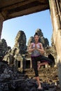 Virtual Woman in Yoga Tree Pose on stones in front of an old Angkor temple