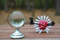 Virus figurine made of plasticine with a gun. Next to it is a small glass globe