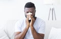 Sick african guy cleaning his snotty nose at home Royalty Free Stock Photo