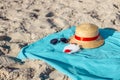 Virus protection mask, straw hat on beach blue towel on sand. Summer holiday and travel concept Royalty Free Stock Photo