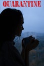 Silhouette of a young broken hearted beautiful girl with a cup of tea on a window background in a cold autumn rainy day Royalty Free Stock Photo