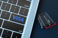 VISA logo on laptop keyboard and miniature shopping cart. 3D Rendering