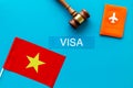 Visa to Vietnam concept. Vietnamese flag near passport and judge hammer on blue background top-down copy space Royalty Free Stock Photo