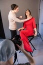 Visagist do makeup for happy woman on photoshoot