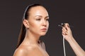 Visagist making makeup for model with aerograph Royalty Free Stock Photo