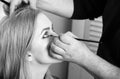 Visagiste applying eye makeup on girl face with brush Royalty Free Stock Photo