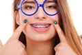 Happy nerdy teenage in eyeglasses showing braces