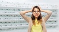 Woman in glasses holding to head at optics store Royalty Free Stock Photo