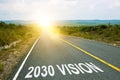 2030 vision inscription on straight road. Sunny morning landscape. Motivational inscription on the road going forward. The