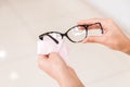 Vision problems. closeup hands of a woman wiping her glasses