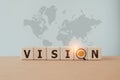 vision text with eye and magnifying glass instead of O, on wooden cube block and world map background for business purpose, Royalty Free Stock Photo