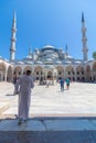 Visit Istanbul background vertical photo. Tourists in courtyard of Blue Mosque Royalty Free Stock Photo