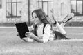 Always visit the library. Happy bookworm. Small child read library book on green grass. Adorable little girl borrow Royalty Free Stock Photo