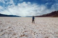 beautiful landscape of Bad Water course in death valley with young manr walking at sunset