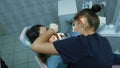 Visit to the dentist. Orthodontist doctor sets up iron braces for a woman with a dental fixator, top view