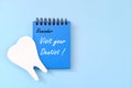 Visit your dentist reminder on blue desk calendar. Dental and oral health care concept. Royalty Free Stock Photo