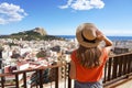 Visiting Alicante in Spain. Traveler girl enjoying view of Alicante cityscape and Mount Benacantil with Santa Barbara Castle and Royalty Free Stock Photo