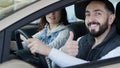 Visiting car dealership. Beautiful family is talking and smiling while sitting in their new car . young man shows finger Royalty Free Stock Photo