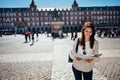 Visiting famous landmarks and places.Cheerful female traveler at famous Plaza Mayor square reading a map. Marid,Spain travel Royalty Free Stock Photo