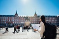 Visiting famous landmarks and places.Cheerful female traveler at famous Plaza Mayor square reading a map. Marid,Spain travel Royalty Free Stock Photo