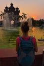 Visiting Laos - Young Woman admires beautiful Patuxai Monument in the city of Vientiane Royalty Free Stock Photo